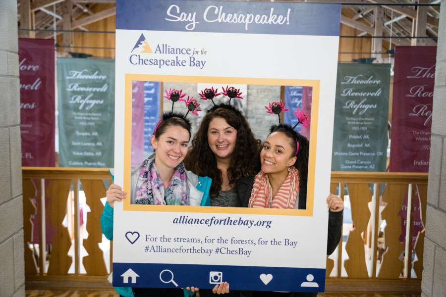 Three women pose with for a picture wearing crab headbands.