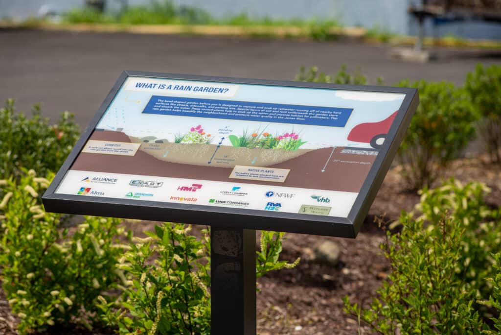 A "What is a Rain Garden?" sign showing a cross section of a rain garden and how rain water flows through it.
