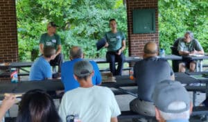 Two people giving a presentation under a pavilion