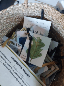 An award gift basket containing gift cards, a watercolor painting and a award certificate.