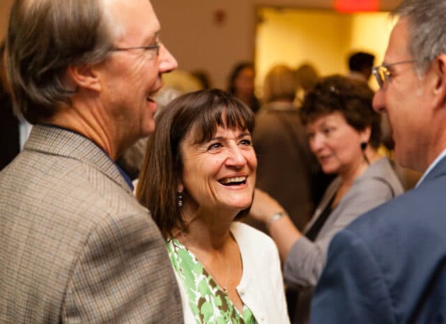 A small group of people smiling while talking.