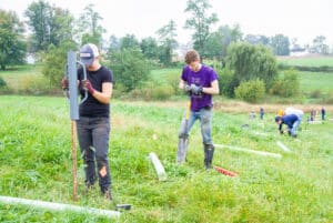 A group of people planting trees in a field