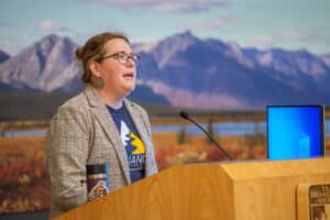 A person speaking behind a podium in an auditorium