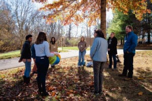 A group of people in a circle throwing a beach ball to eachother