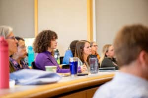 People sitting at tables and taking notes