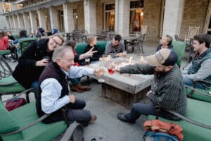 A group of people sitting around a patio table, smiling and talking