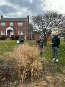 Three people gathered around a landscaping installation