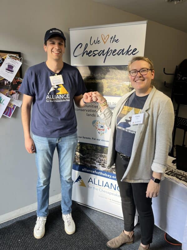 Kate and Mason smiling and knocking their knuckles celebrating a successful event.