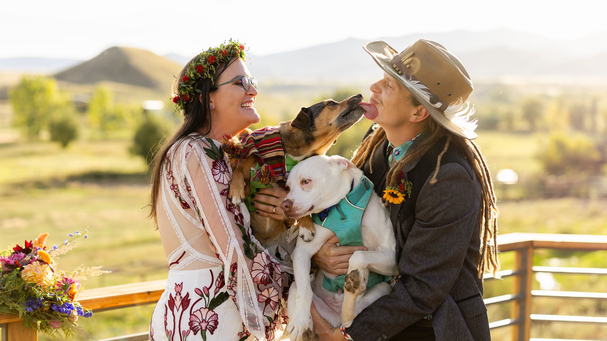 Two people holding dogs on a farm