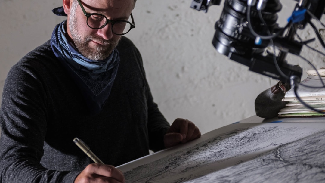 A person looking at a map on a drafting table