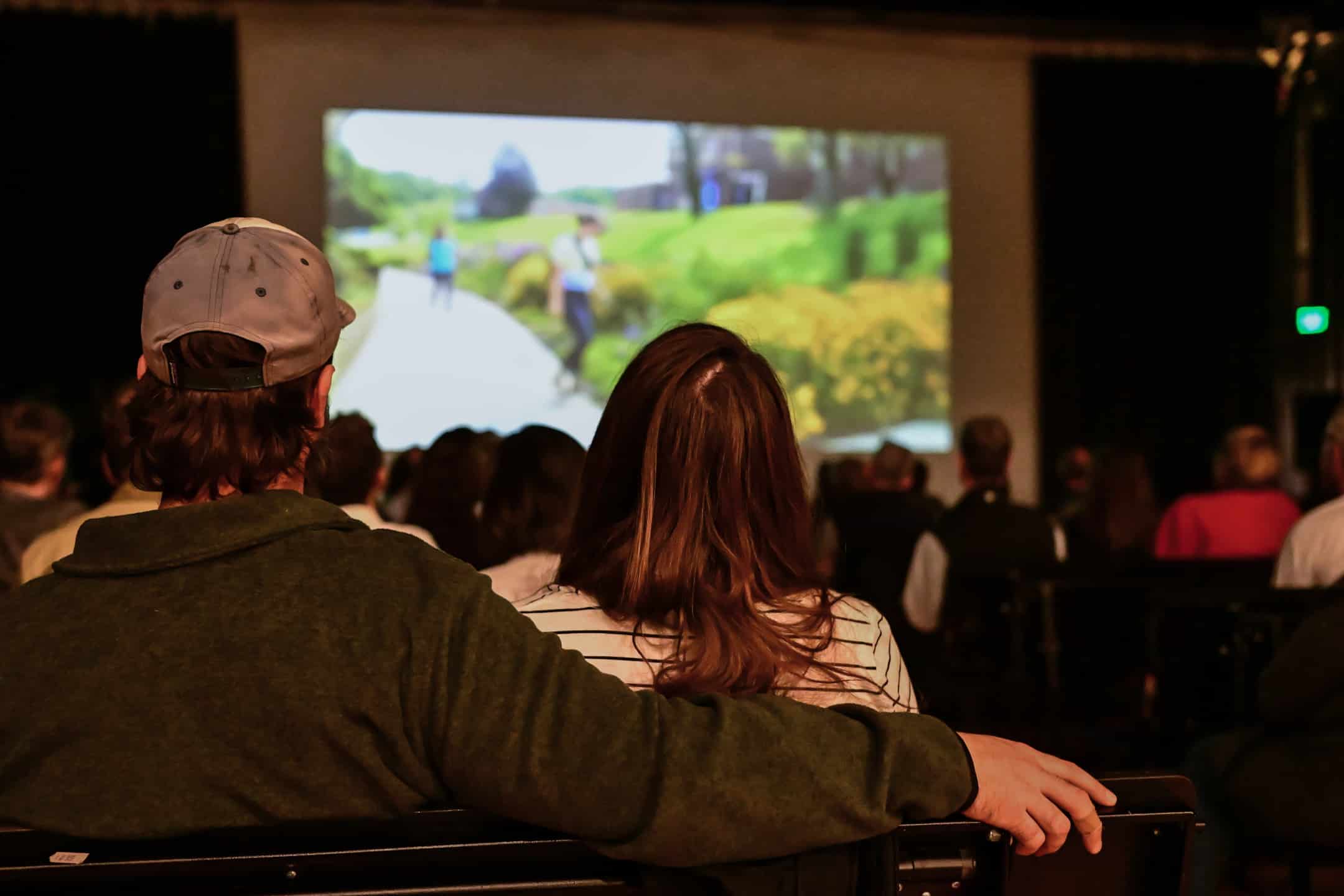 Two people watching a film in the background