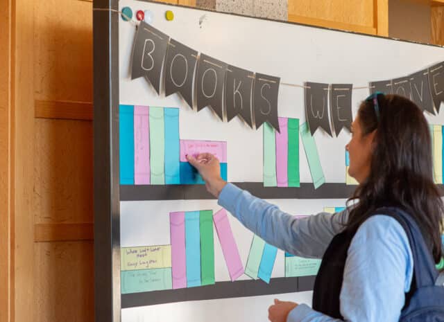 A person placing a sticker on a book recommendation to indicate agreement