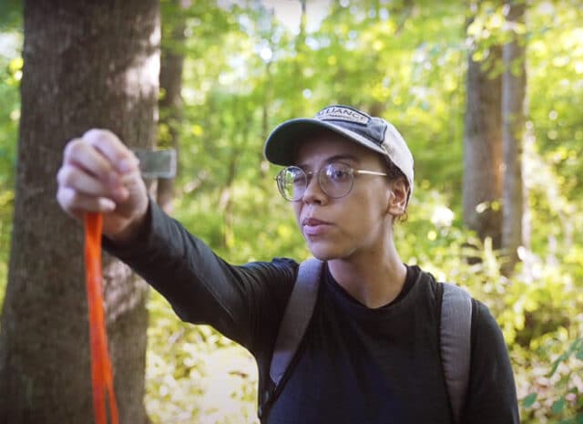 A person holding up a clear strip of plastic and looking through it