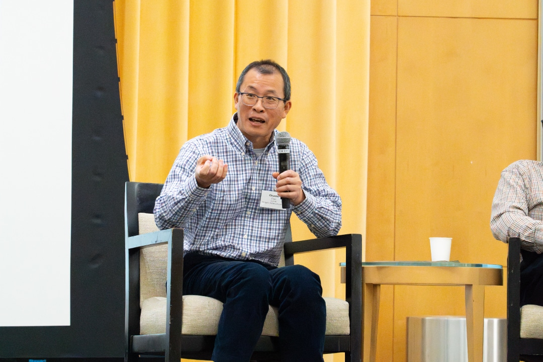 a person speaks into a microphone on a stage