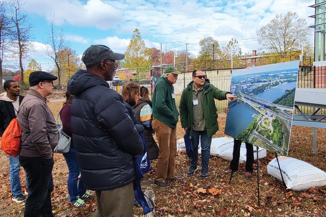 A group of people look at an aerial photo of a bridge