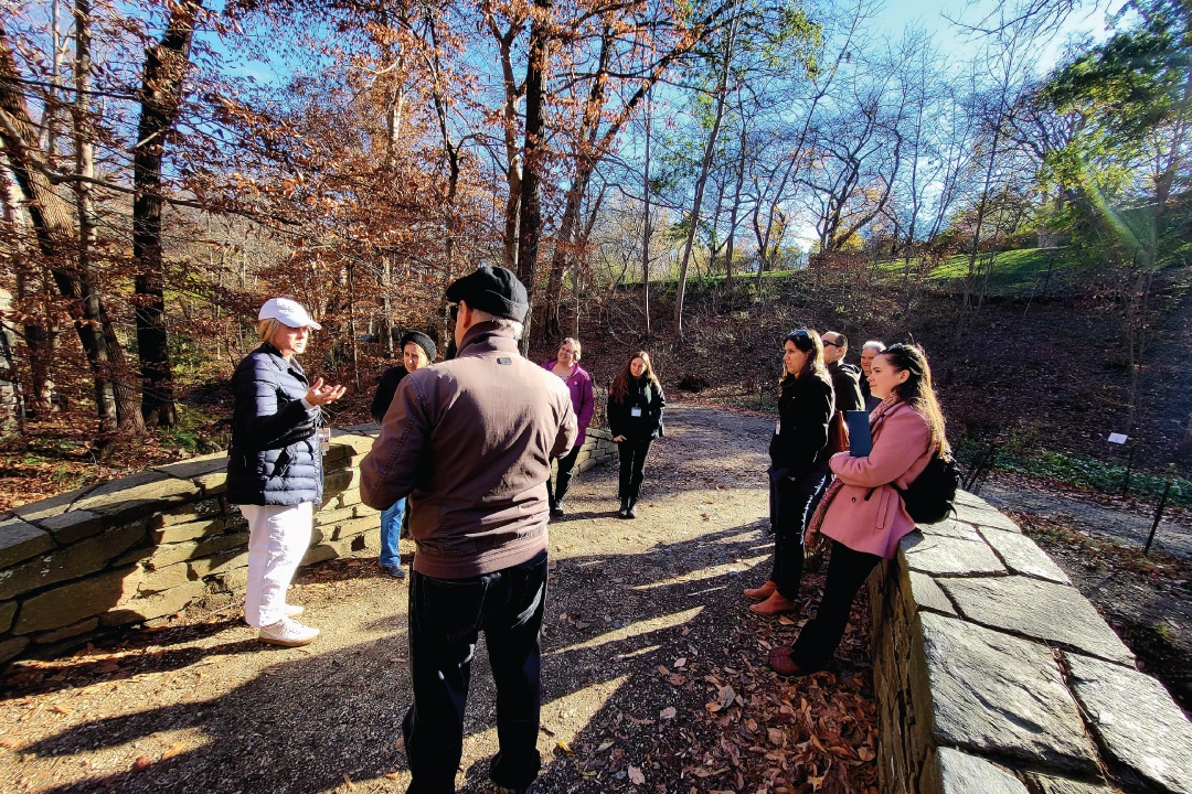 a group of people stand on a small stone bridge