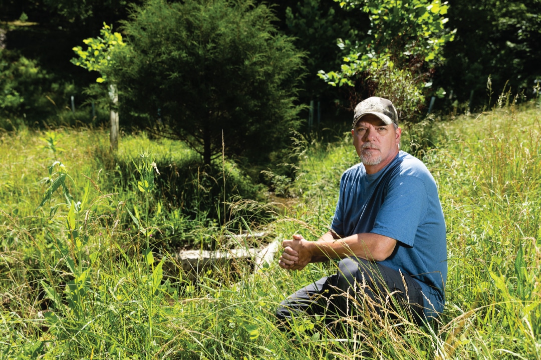 a person crouching in a field