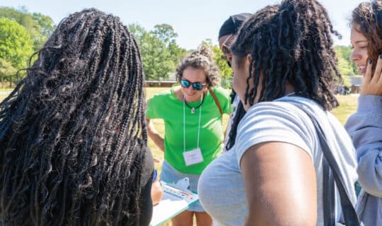 a group of people look at a clipboard