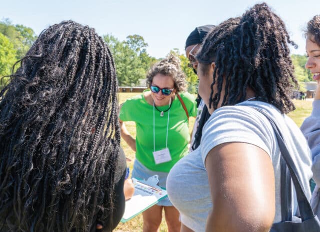 a group of people look at a clipboard