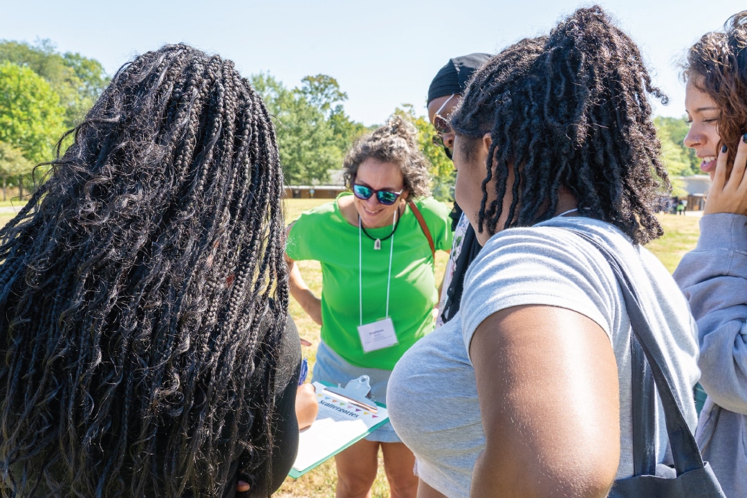 a group of people look at a clipboard