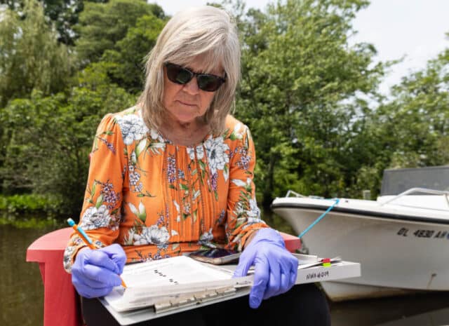 a person writes on a clipboard on a dock