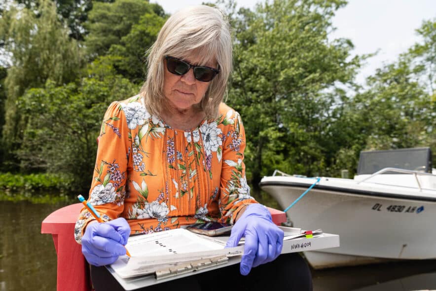 a person writes on a clipboard on a dock