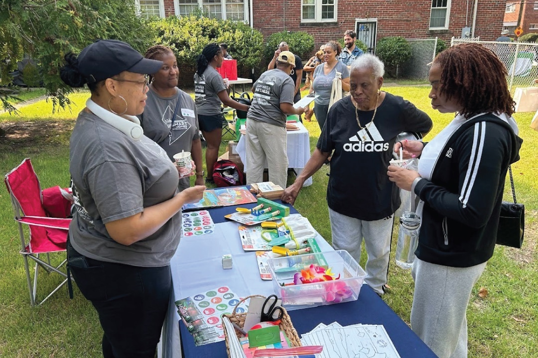 people look at items on a table in a backyard