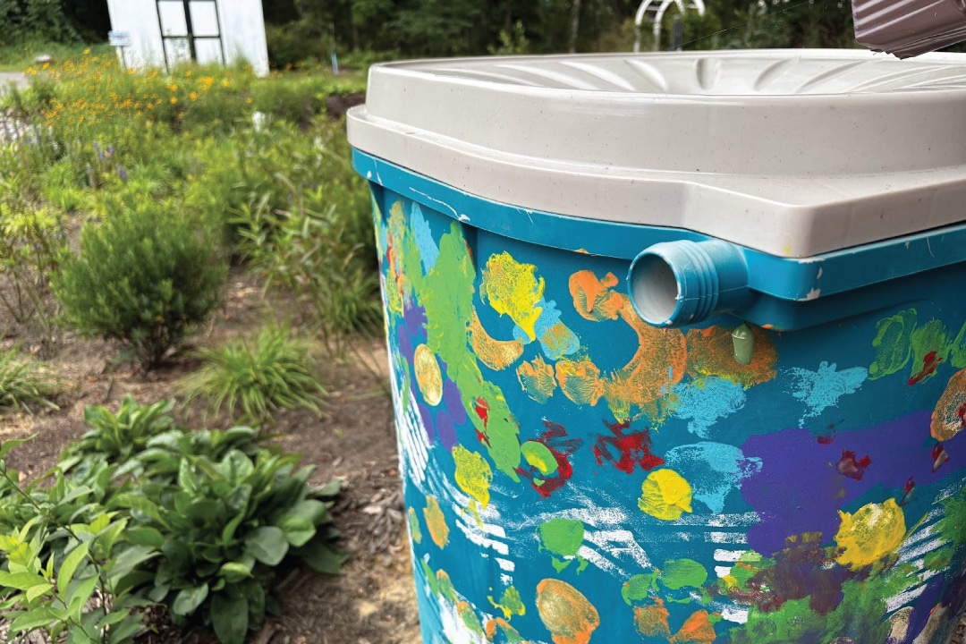 a painted blue rain barrel in a garden