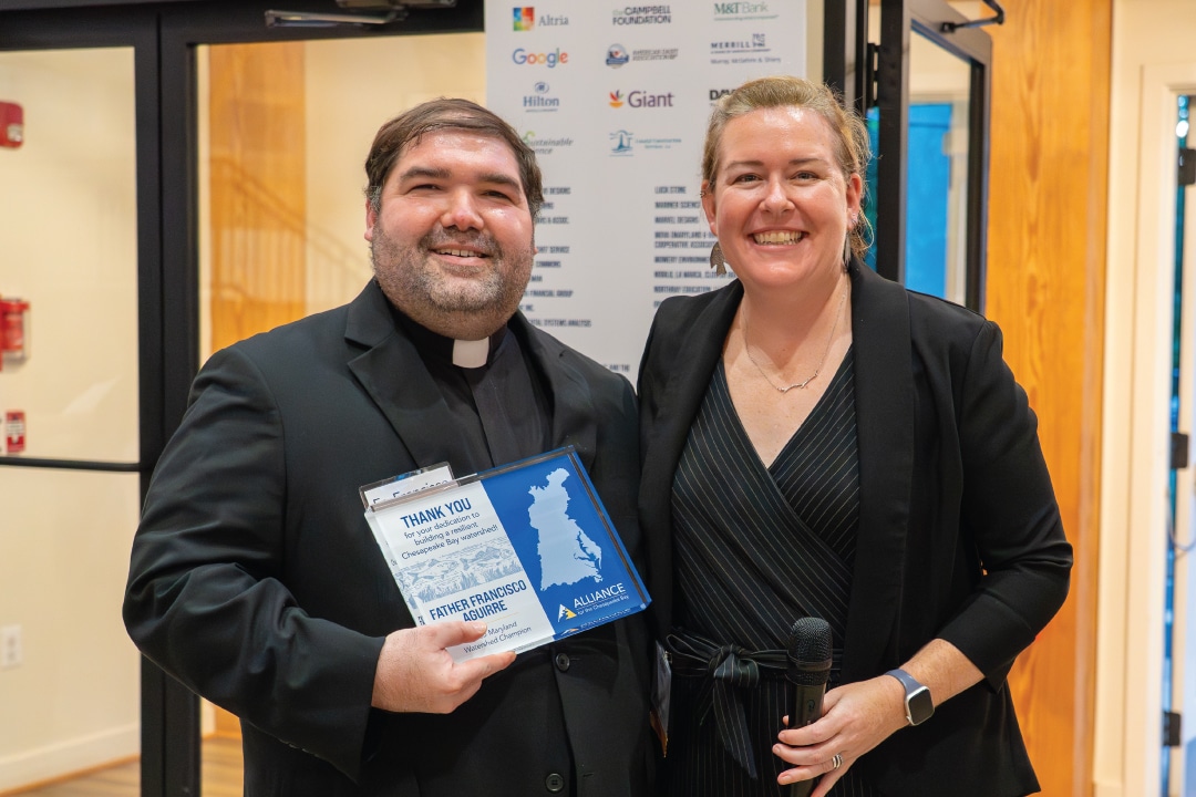 two people pose for a photo while the person on the left holds an award plaque