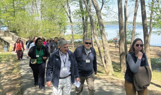 a group of people walking down a riverside path