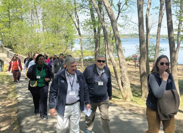 a group of people walking down a riverside path