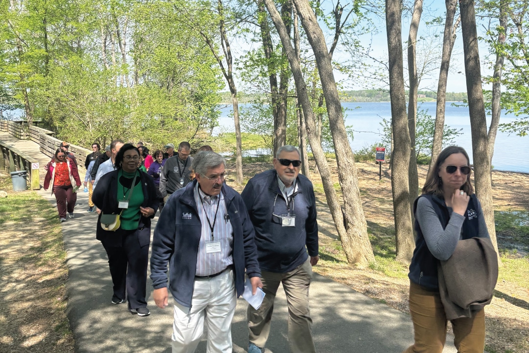 a group of people walking down a riverside path