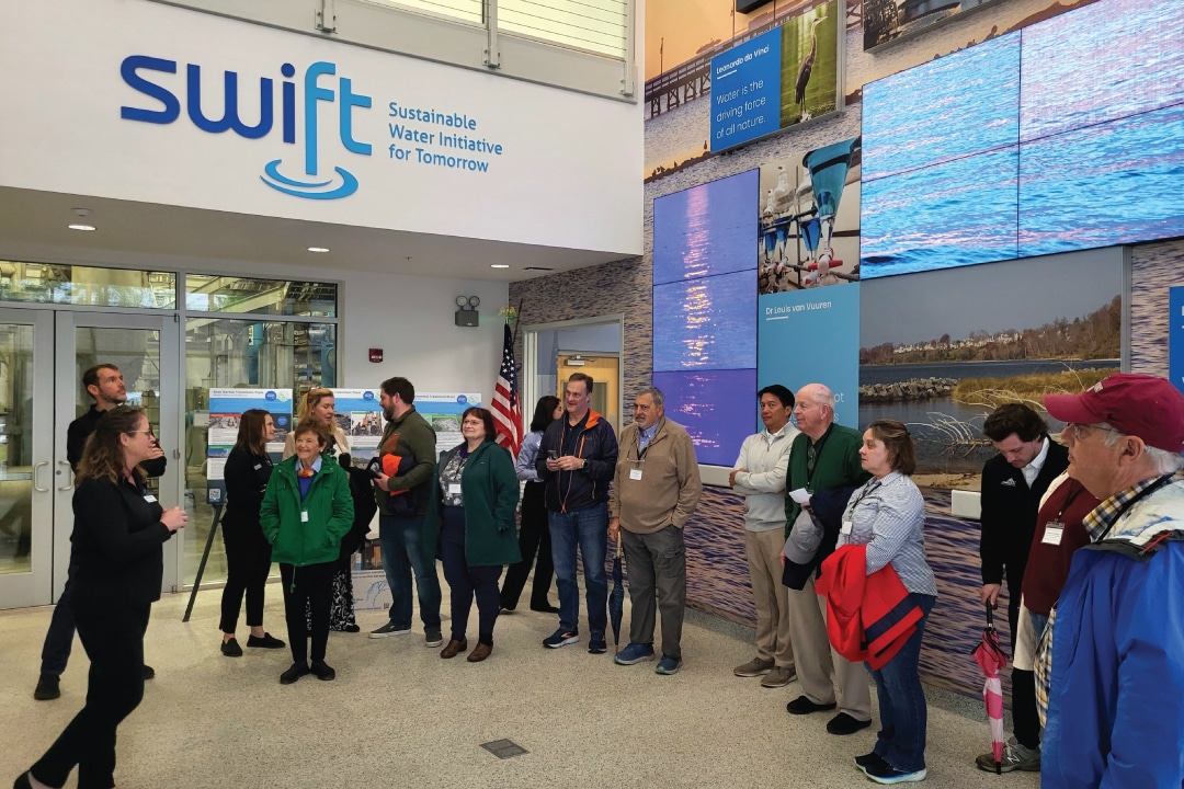 a group of people listen to a speaker in a lobby