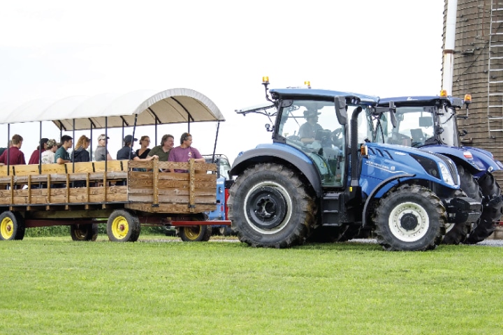 people ride in a wagon being pulled by a tractor