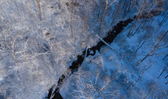 an aerial shot of a snowy creek