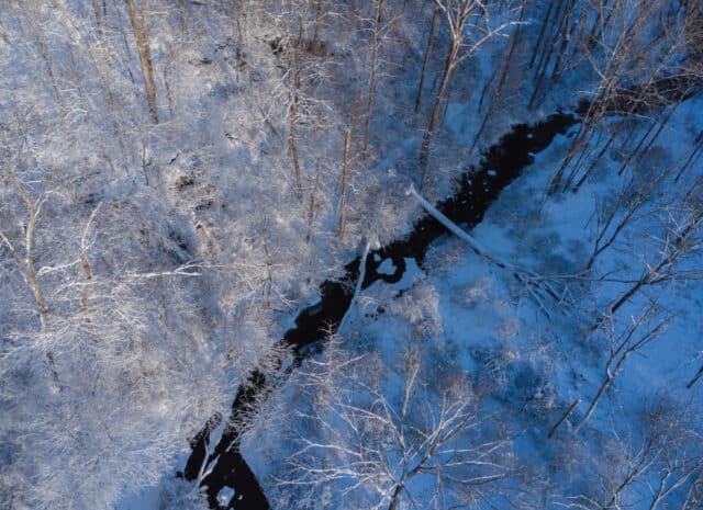 an aerial shot of a snowy creek