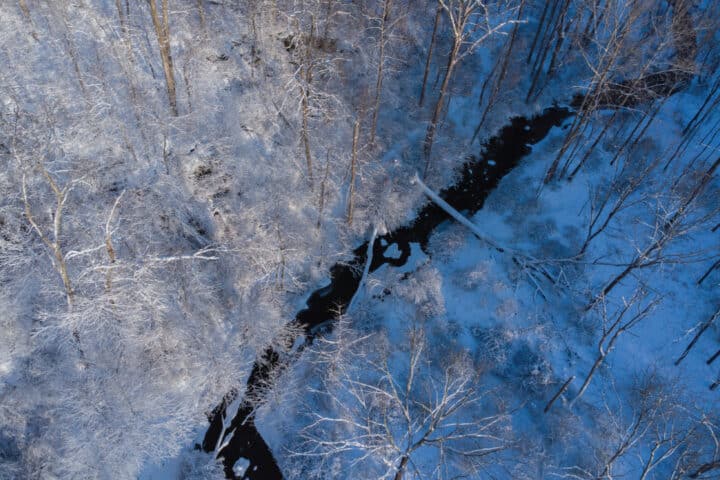 an aerial shot of a snowy creek