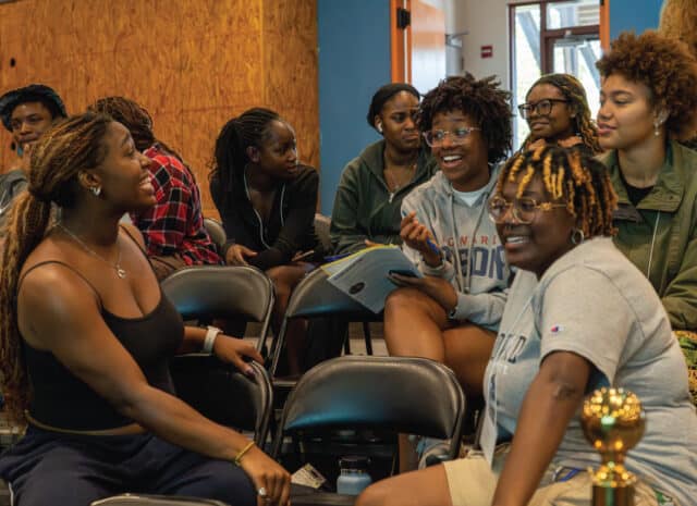 A group of people smile as they talk to each other.