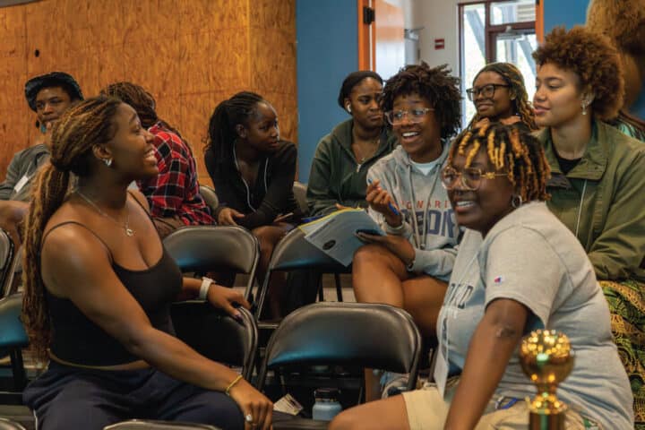 A group of people smile as they talk to each other.
