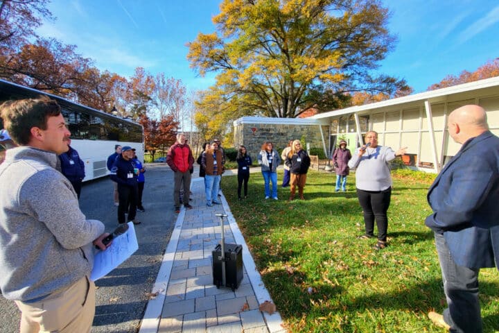 a person speaks to a group of people gathered around them