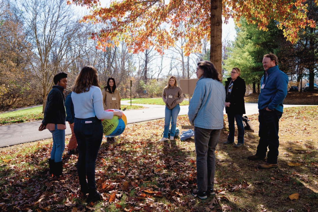 a circle of people pass a beach ball