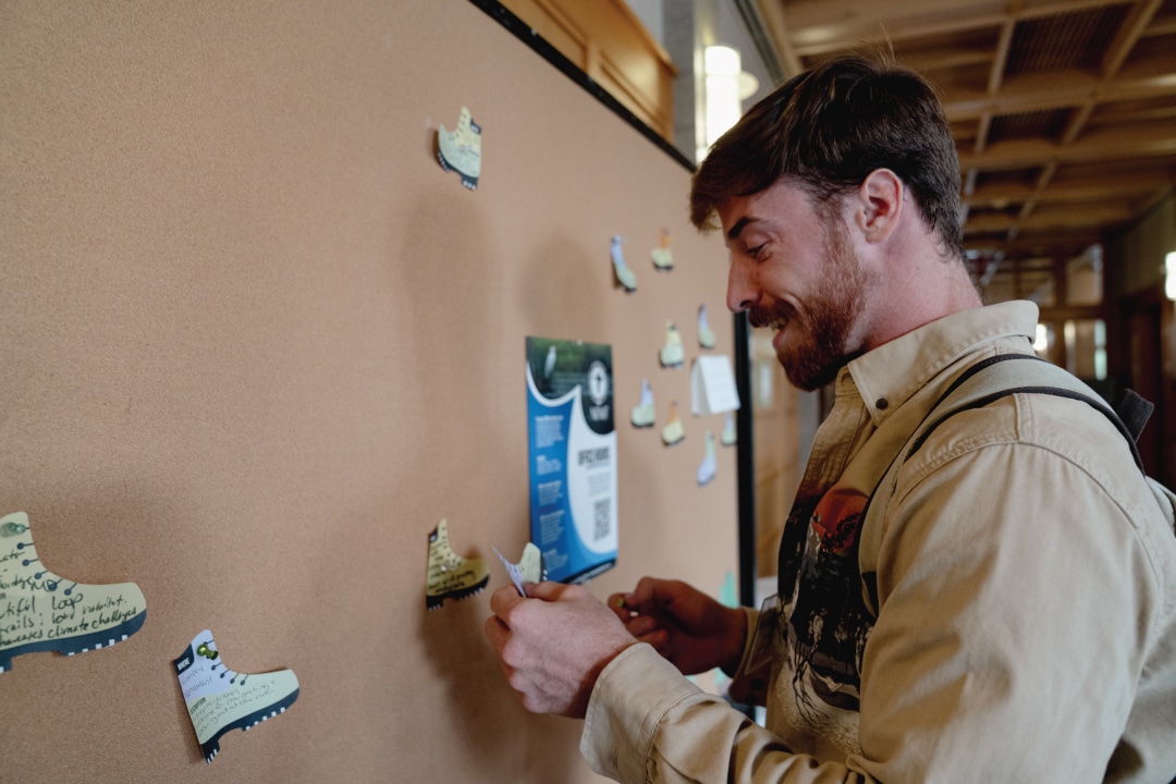 a person sticks a boot shape sticker to a bulletin board