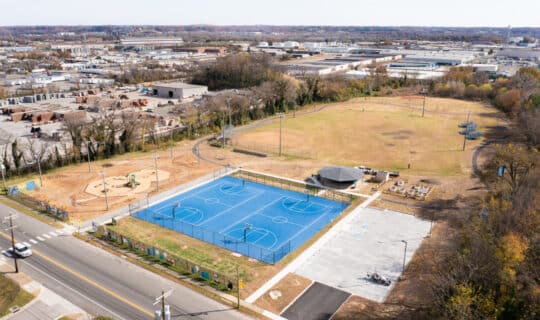 an aerial view of a park with blue basketball courts