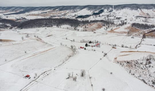an aerial shot of a snowy farm