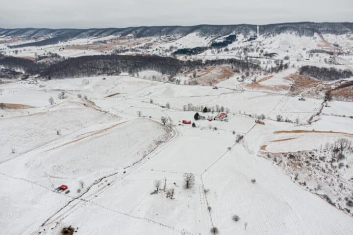 an aerial shot of a snowy farm